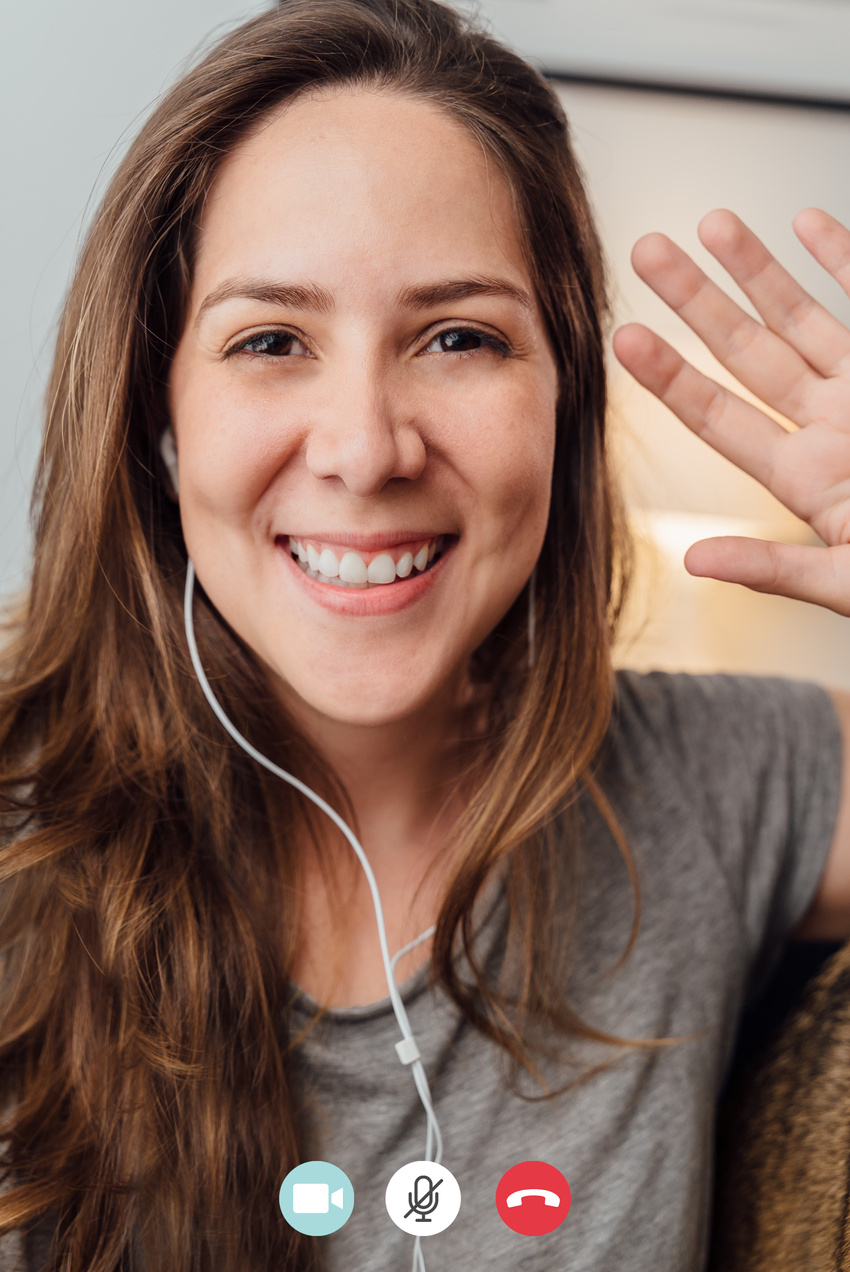 Portrait of happy 30s aged beautiful girl making facetime video calling with smartphone at home. waving on phone screen. Using conferencing meeting online app, social distancing, concept